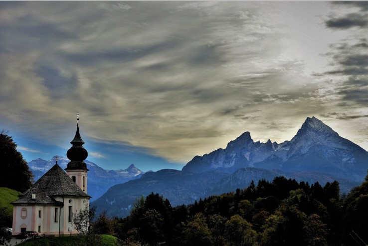 和瓦茨曼峰雄峙的玛丽亚-盖恩教堂。天空中圣光降下，落在瓦茨曼峰上。 